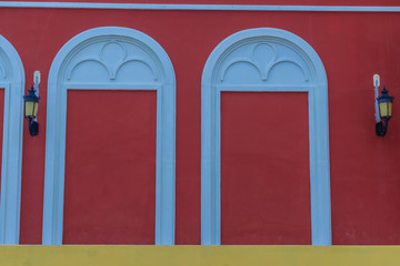 Classic white arch door pattern on the red wall background.