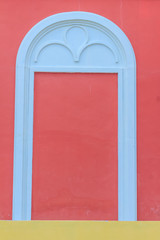 Classic white arch door pattern on the red wall background.