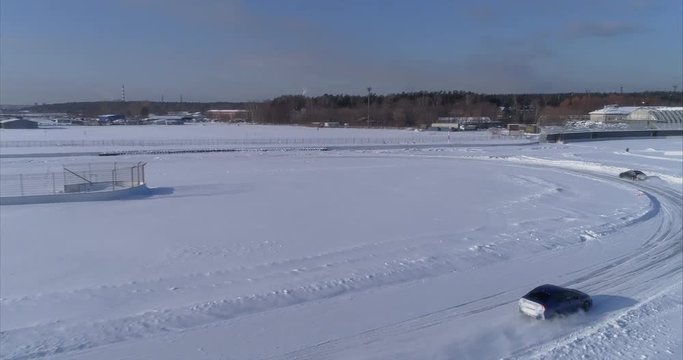 Blue and black subaru wrx racing on the ice ring, aerial view