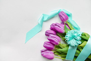 purple tulips with blue ribbon on an isolated white background festive bouquet for the birthday, March 8, baby shower, mother's day, women's day. floristic composition