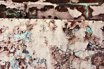 Rusty cracked pink-yellow paint surface with turquoise details close up, grunge horizontal shabby background