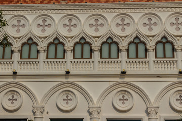  Abstract French balconies which decorated in circle shape above arch door on stucco wall background.