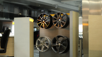 Designer alloy wheel rims on a wooden rack at car tuning showroom