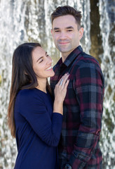 Happy Millennial Couple Standing in-front of a Waterfall