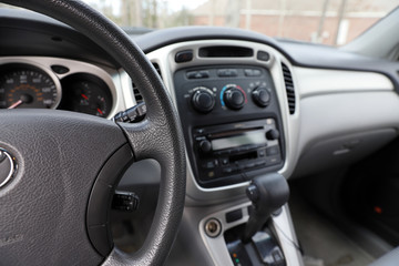 Obraz na płótnie Canvas Automobile interior with steering wheel, gear shift and controls