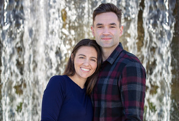 Fototapeta premium Happy Millennial Couple Standing in-front of a Waterfall Horizontal