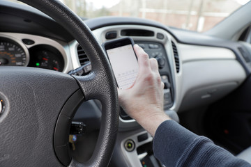 Distracted driver with phone in hand, vehicle interior
