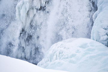 Fototapeta na wymiar Icelandic Iceland waterfall frozen and covered in snow during winter