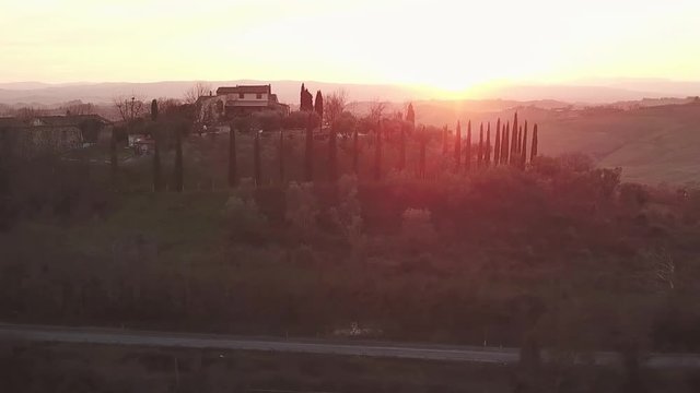 Aerial view, Tuscany countryside at sunset, Country house on top of a hill with cypress around