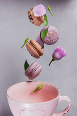 Sweet french macaroons falls mixed with flowers in empty pink cup