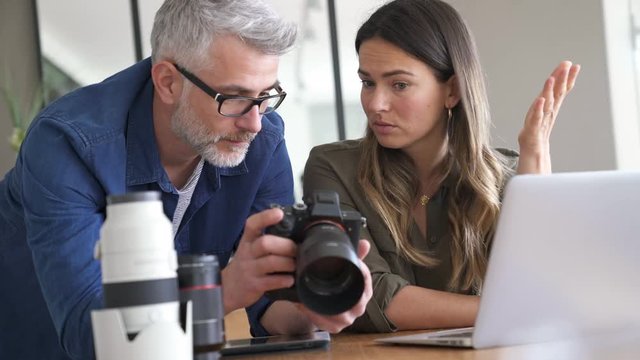Photographers in office checking on picture shots