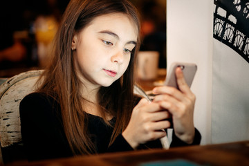 Girl with an smartphone at the restaurant