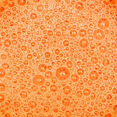 Orange carrot milkshake with bubbles texture