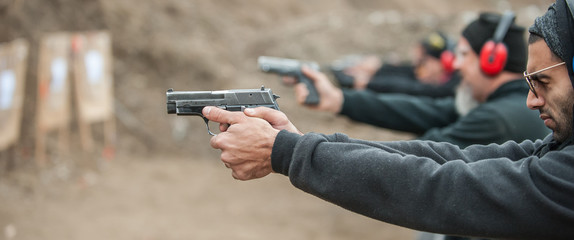 Group of civilian practice gun shooting on outdoor shooting range © guruXOX