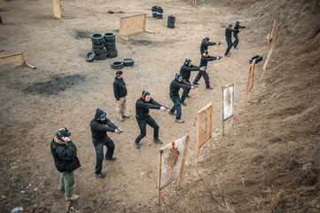Students group with instructors practice gun shooting on shooting range