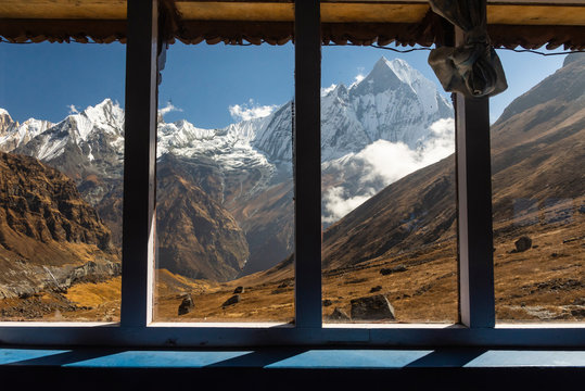 Scenic view of snowcapped mountains against blue sky seen through windows