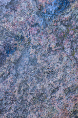 Texture of granite close up. Granite rock with reddish color. Background from solid stone. Pattern with natural material