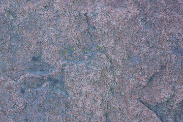 Texture of granite close up. Granite rock with reddish color. Background from solid stone. Pattern with natural material