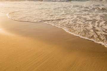 Fototapeta na wymiar Olas rompiendo en la orilla de la playa al atardecer, Waves breaking on the beach shore at sunset