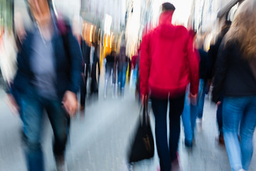 picture of people walking on a shopping street in the city, with camera made motion blur effect