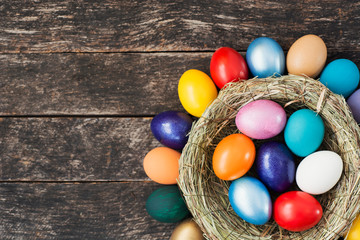 bright Easter colored eggs in Birds Nest.   Top view with copy space 