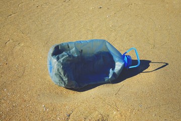 Big plastic bottle at the sand 