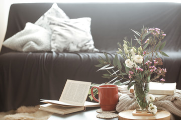 Cozy home interior living room with a black sofa and a vase of flowers