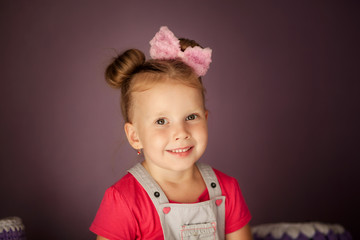 happy beautiful girl 3-4 years old sitting on the dresser with makeup laughing 