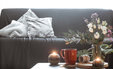 Cozy home interior living room with a vase of flowers and candles