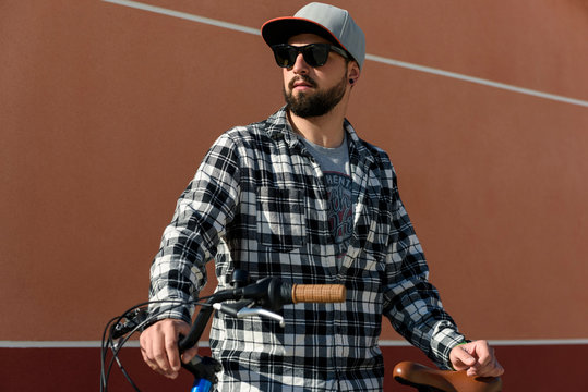 Young man wearing sunglasses standing with bicycle outdoors
