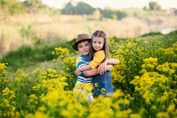 Fototapeta premium happy cute children, brother and sister, boy and girl on the nature in the park hug, true friendship
