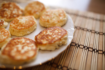 Close up cheese pancakes, cheese cakes, cottage cheese pancakes on a white plate background.
