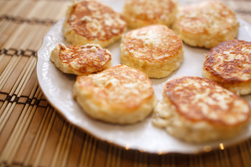 Close up cheese pancakes, cheese cakes, cottage cheese pancakes on a white plate background.