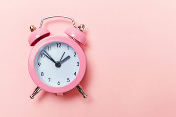 Ringing twin bell vintage classic alarm clock Isolated on pink pastel colorful trendy background....