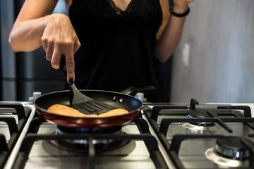 Young woman making french bread in frying pan