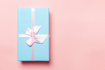 Christmas New Year birthday valentine celebration present romantic concept. Small gift box wrapped blue paper isolated on pink pastel colorful trendy background. Flat lay top view copy space