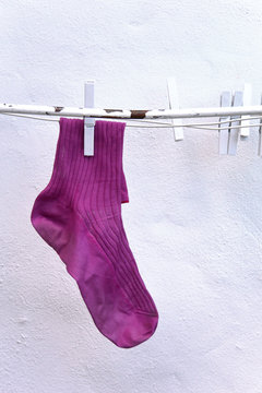 Eine einzelne pinke Socke auf W&auml;scheleine