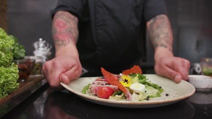 Chef is finishing meal teasty for guest of restaurant culinary creative chef cookery food drink cook cuisine garnish dish leafs tomatoes food gourmet plate industrial preparing presentation salad