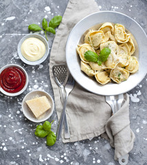 fresh tortellini in a bowl with basil and parmesan