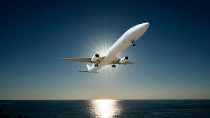 Fototapeta na wymiar Airplane flying in the sky over tropical sea