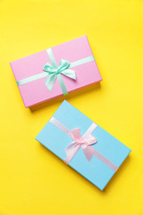 Christmas New Year birthday valentine celebration present romantic concept. Gift box wrapped blue pink paper isolated on yellow colourful trendy modern fashion background. Flat lay top view copy space