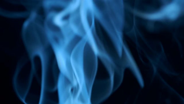 Smoke rising graceful twists on black background blowing from bottom to top. Closeup, ProRes, 50 fps