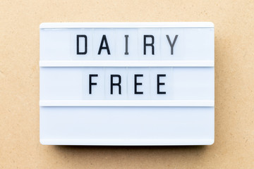 White lightbox with word dairy free on wood background