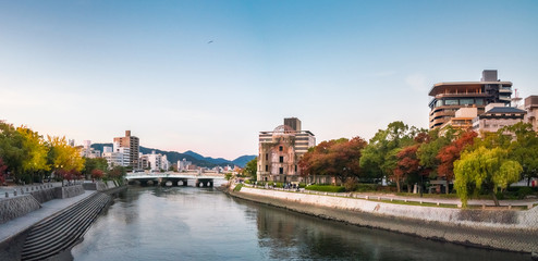 Naklejka premium Hiroshima Cityscape at sunset on the side of Motoyasu River in Japan with the Peace Memorial Park on the left hand side and the ruin of the Atomic Bomb Dome on the right.