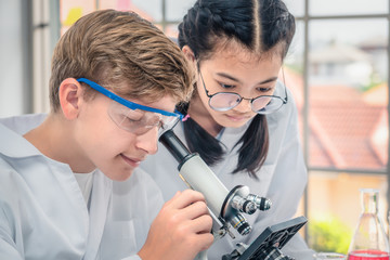 students using microscope in science laboratory class