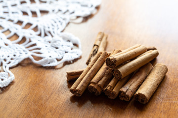 Cinnamon pile on a wooden table near a crochet doily