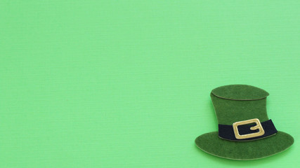 Green St Patrick's day hat laying flat on a green background with writing space