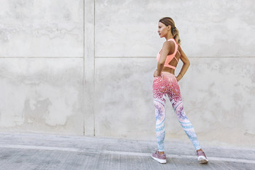 Obraz na płótnie Canvas Fitness sport woman in fashion sportswear doing yoga exercise over gray wall