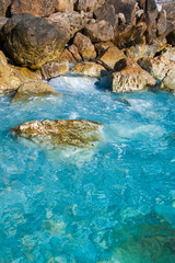 blue waves crashing against the rocks of the beach