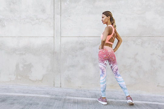 Fitness sport woman in fashion sportswear doing yoga exercise over gray wall © Alena Ozerova